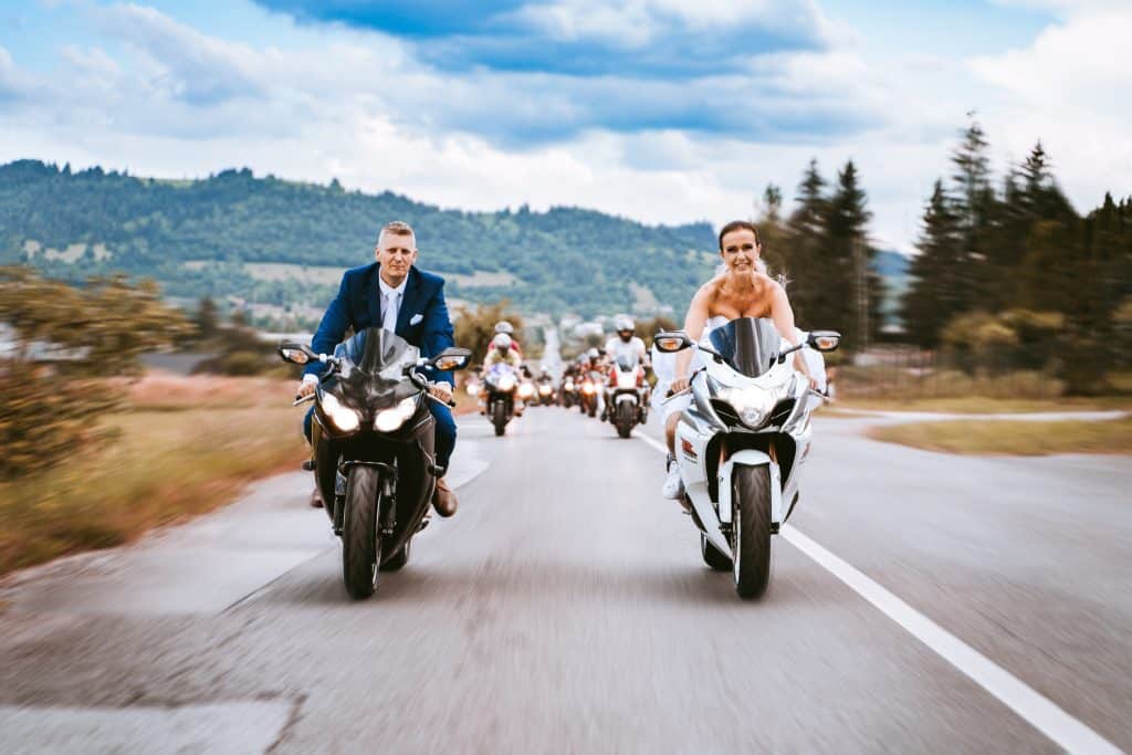 Ella a Miro jazdia na motorkách na čele kolóny, v pozadí hory