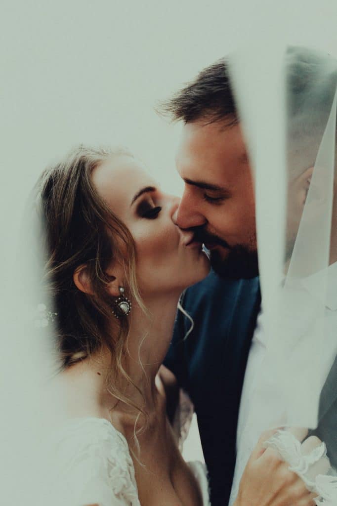 Dominika a Michal sa bozkávajú, záber rámuje biely závoj